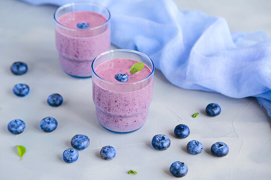 Fresh Cold Blueberry Smoothie in Glass Decorated with Blue Fabric