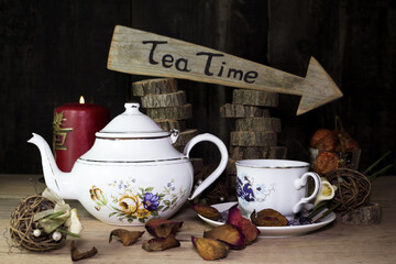 Cup of Tea and Teapot On Wooden Table. Arrow Sign With Text, Tea Time Written On It in The Background