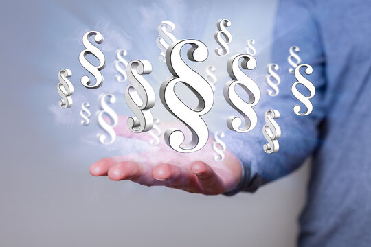 Hand mit Paragrafen - Gesetze und Vorschriften