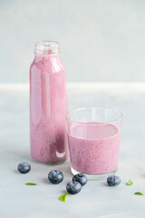 Fresh and Cold Blueberry smoothie in a Borrle on Grey Background 
