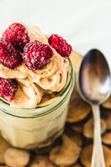 Chocolate banana ice cream, raspberries in a glass jar, close up.