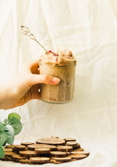 Beautiful woman holding in her hand glass jar of chocolate icecream