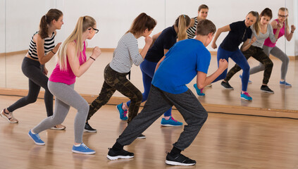 Fototapeta na wymiar teenage boys and girls learning in dance hall