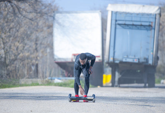 Black male riding hoverboard