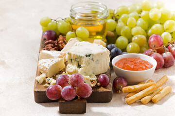 cheeseboard, fresh grapes and honey on a white background