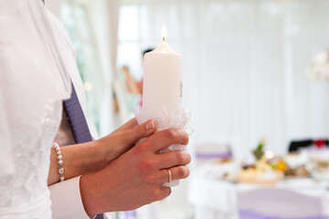 Fototapeta na wymiar burning candles in the hands of the newlyweds