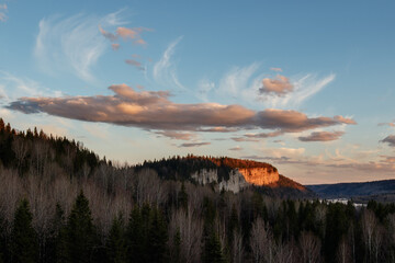 Spring landscape with contrast clouds and highlighted by sunlight mountains