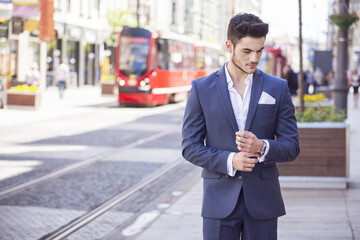 Young handsome businessman dressed smartly, walking through the city