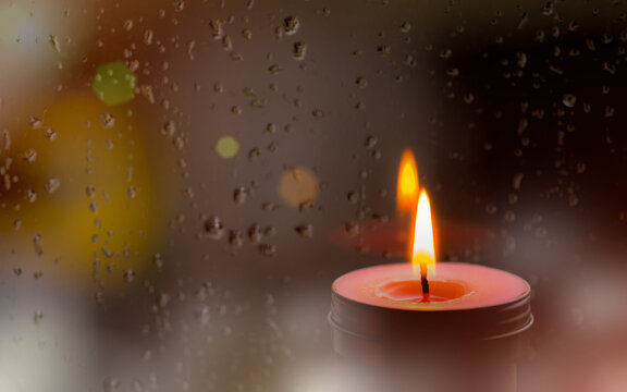 Vintage Image Of Light Of Pink Candle In The Front At Window With Blurred Rain Drops And Low Light Nature Background