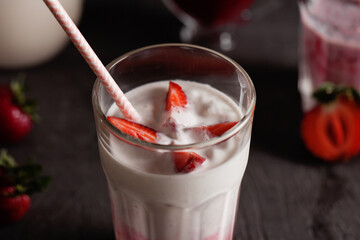 Milkshake of strawberries in a glass on the table