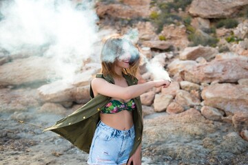 Beautiful girl outdoor with with smoke bomb