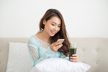 Asian woman using smartphone sitting on couch