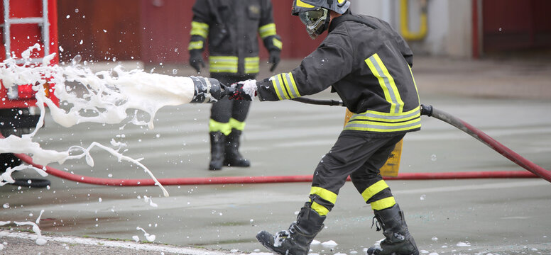 Firefighters while extinguishing the fire with foam