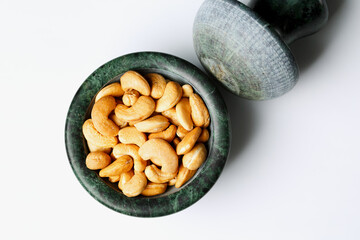 Roasted cashew nuts in a marble mortar