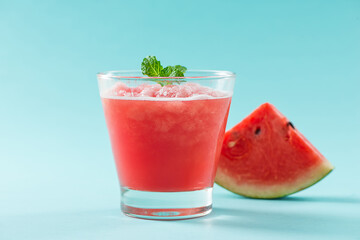 Glass of healthy watermelon juice in summertime on blue background.