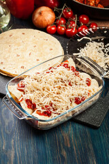 Traditional mexican enchiladas with chicken meat, spicy tomato sauce and cheese in heat resistant dish