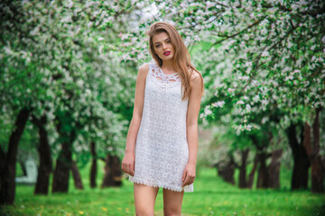 Naklejka premium young beautiful model in white dress in the summer garden