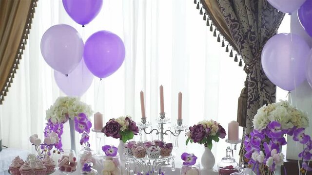 Decor, sweet table. White table with sweets. Wedding cakes and flowers. Sweet balls. Empty glasses with straws. Pancake.