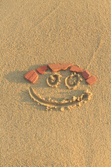 Fototapeta na wymiar Happy smiley face drawn on sand, Handmade smiley face, Beautiful fine sandy beach with smiley face