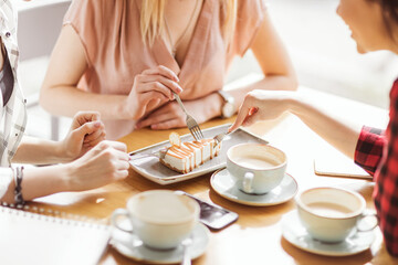 young girls eating cake and drinking coffee at cafe, coffee break - obrazy, fototapety, plakaty