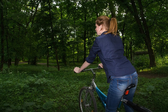 Portrait Of A Smiling Young Woman Riding Bicycle With Groceries In Basket