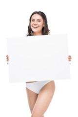 Smiling young woman in underwear holding blank banner and looking at camera