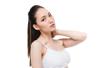 portrait of tender asian girl posing while looking at camera isolated on white