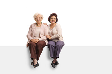 Two elderly women sitting on a panel