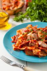 Pappardelle pasta with tuna, in tomato sauce.
