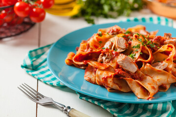 Pappardelle pasta with tuna, in tomato sauce.