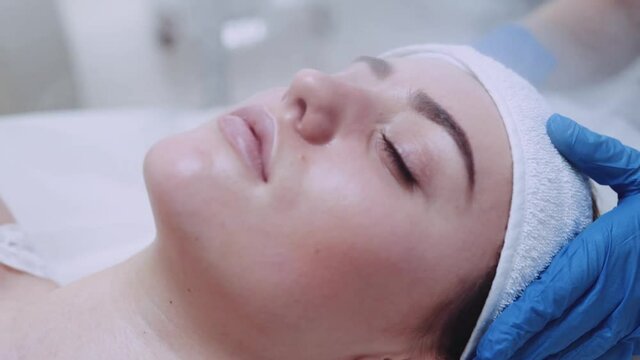 Extreme close up view of a beautiful female&rsquo;s face with closed eyes being cleaned with steam therapy in beauty spa. Enjoying the spa, professional cosmetology tool. Being beautiful.
