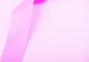 Pink ribbon on white background. Horizontal shoot. Copy space.