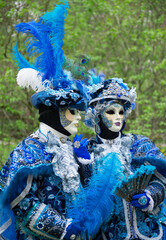 Obraz na płótnie Canvas Unrecognizable people in venetian masks on street carnival.