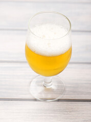 Glass of beer on wooden table.  