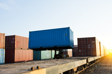 Fototapeta premium Forklift handling container box loading to train / selective focus.