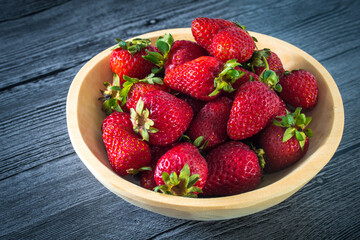 A wooden plate with strawberries