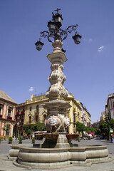 Fototapeta na wymiar Sevilla (Spain). Fuente-lamppost in the Virgen de los Reyes square in the city of Seville