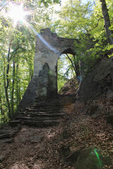 Stone gate in forest with strong light. Czech landscape