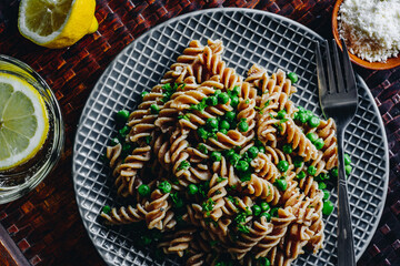 Fusilli pasta with green peas herbs and grated parmesan. Sparkling water with lemon. 
