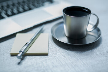 office working desk top view with laptop, notepad and coffee with cookie