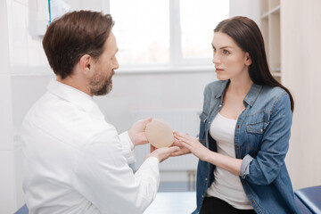 Wise admirable woman asking about details of plastic surgery