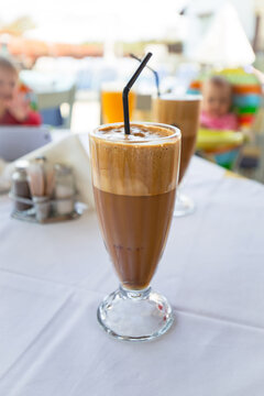 Glass of freppe - greek cold iced coffee on table