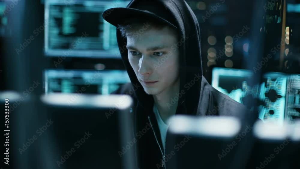 Poster hooded teenage hacker successfully attacks global infrastructure servers with virus. shot on red epi