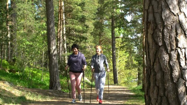 Nordic walking outdoor activity for all ages. Two active women working out in Park.