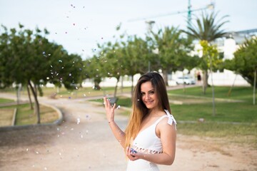 Beautiful young girl in a park with confetti