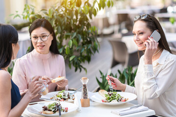 Happy lady telling by phone in cafe