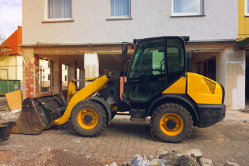 Yellow tractor on construction site at sunset