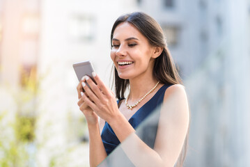 Happy woman sending sms by phone