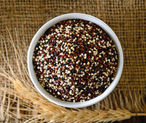 Quinoa seeds in bowl on wood