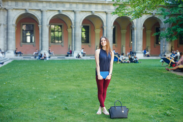 Fototapeta premium A young woman in front of university building